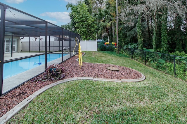 view of yard featuring a fenced in pool and glass enclosure