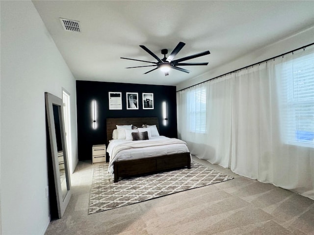 bedroom with ceiling fan and light carpet