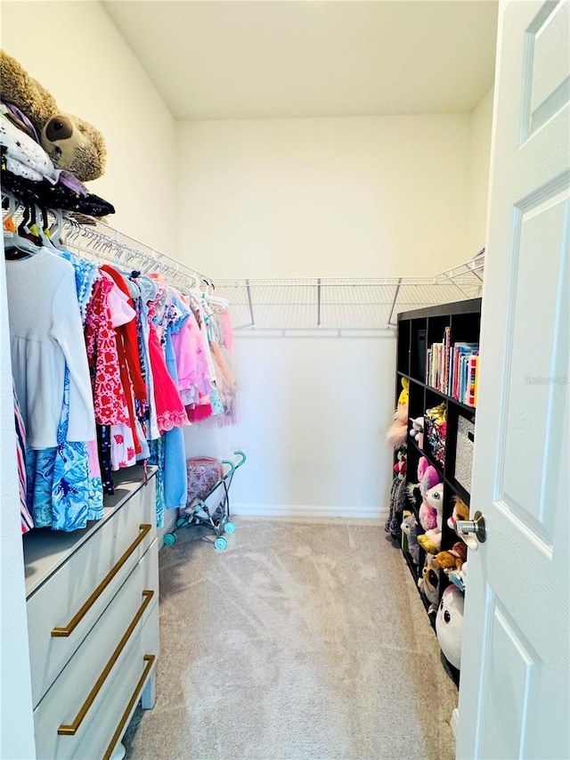 walk in closet featuring light colored carpet