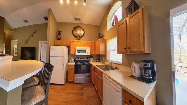 kitchen with white appliances, lofted ceiling, sink, and light hardwood / wood-style flooring