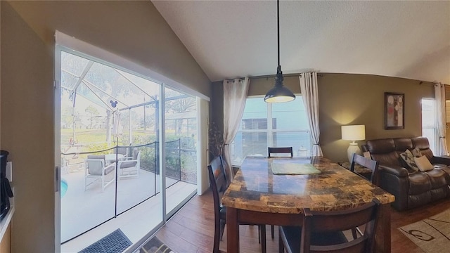 dining area with hardwood / wood-style floors and vaulted ceiling