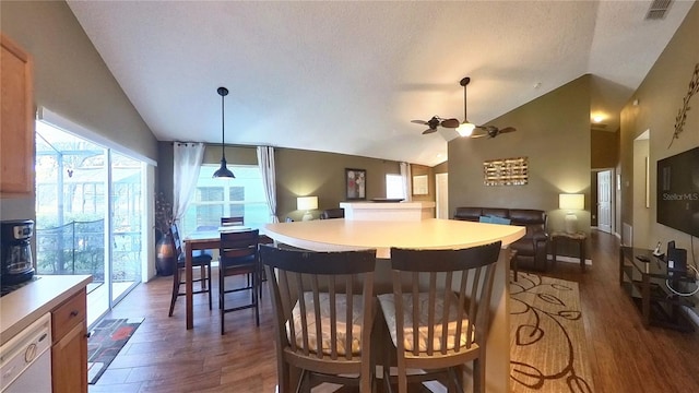 kitchen with lofted ceiling, dark hardwood / wood-style floors, dishwasher, and a breakfast bar area