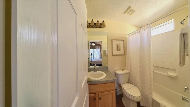 full bathroom with shower / tub combo with curtain, vanity, toilet, and a textured ceiling