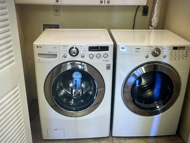 laundry room with washer and dryer and tile patterned floors