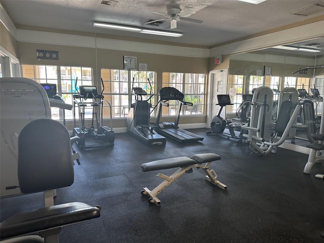 workout area with ceiling fan and a textured ceiling