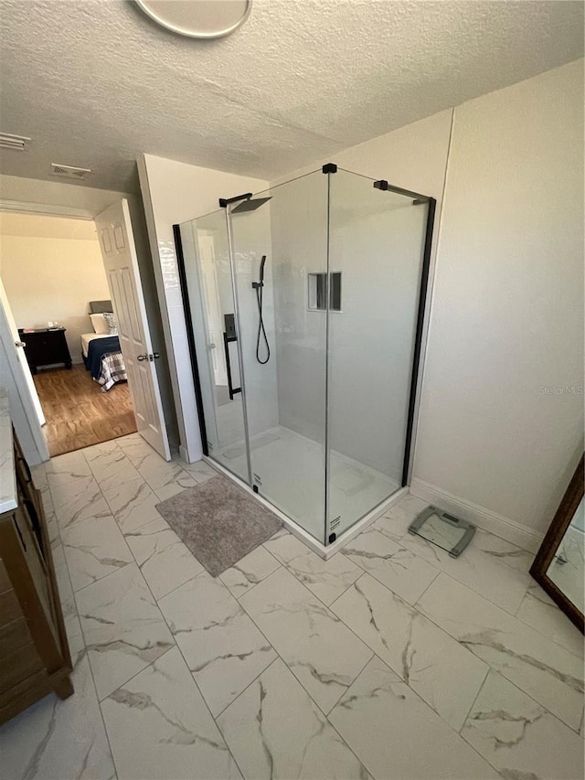 bathroom with visible vents, marble finish floor, a stall shower, and a textured ceiling