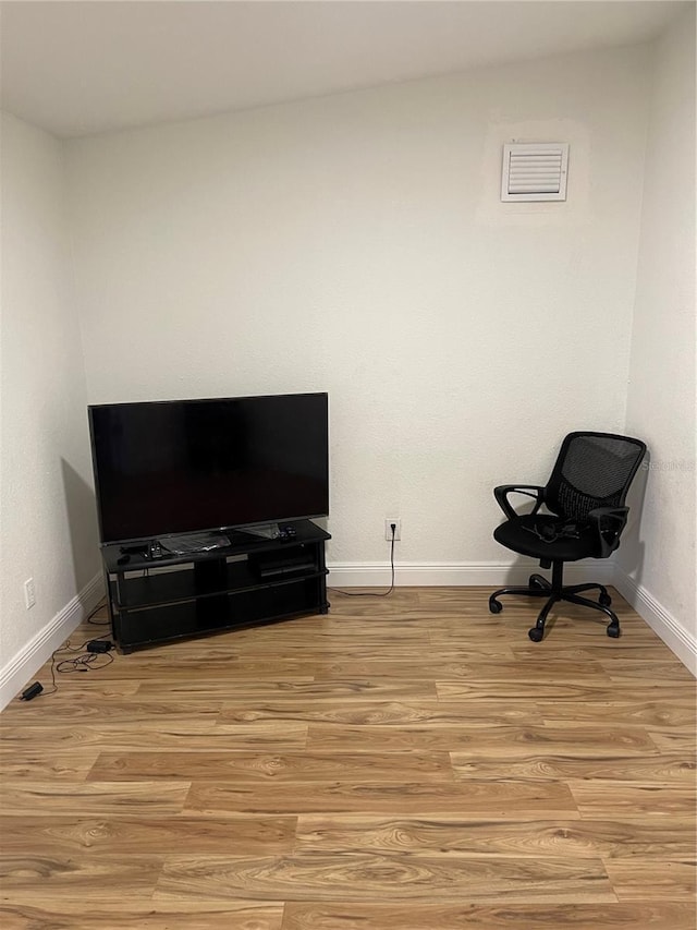 living area with visible vents, baseboards, and light wood finished floors