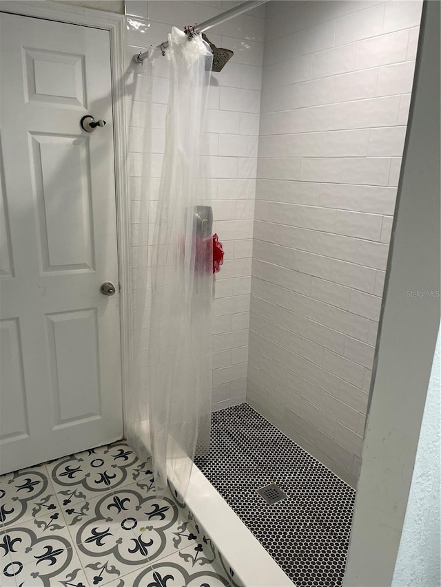 full bath with tile patterned flooring and a shower stall