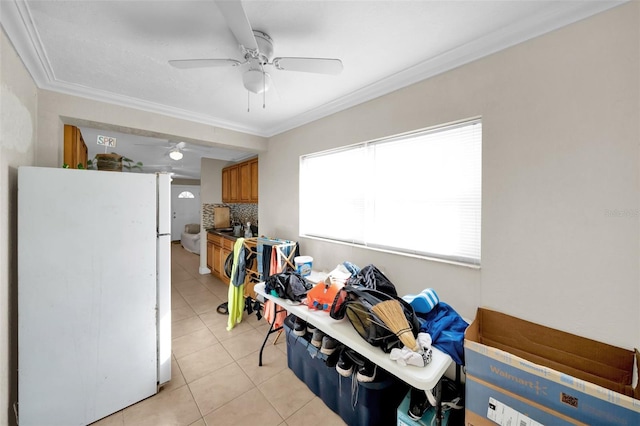 kitchen with tasteful backsplash, white fridge, light tile patterned floors, ceiling fan, and crown molding