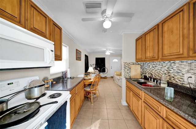 kitchen featuring sink, white appliances, built in desk, light tile patterned flooring, and decorative backsplash