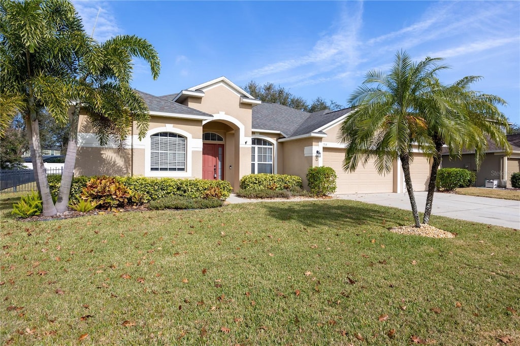 ranch-style house featuring a garage and a front lawn