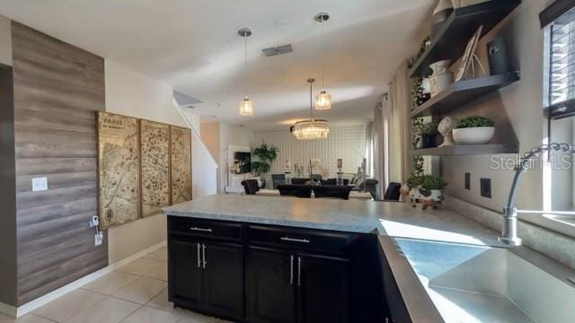 kitchen with pendant lighting, light tile patterned floors, sink, and kitchen peninsula