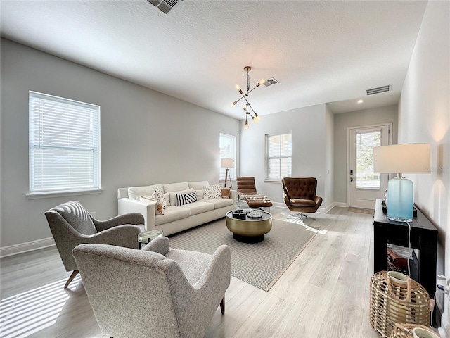 living room featuring a textured ceiling and light wood-type flooring