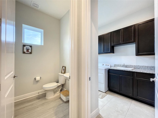 bathroom with toilet, vanity, washer / clothes dryer, and wood-type flooring