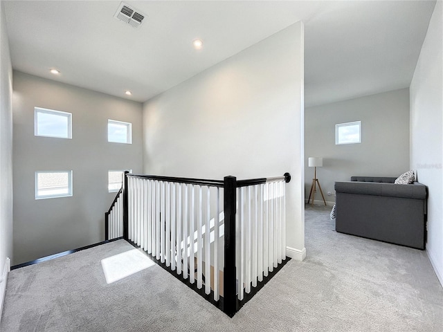 hall featuring light carpet and a healthy amount of sunlight