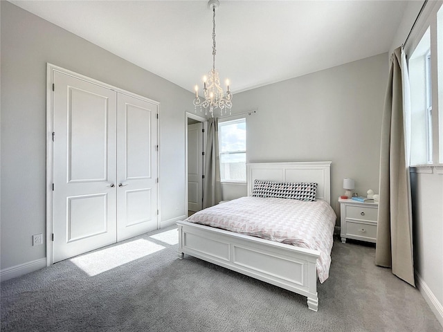 carpeted bedroom featuring a chandelier and a closet