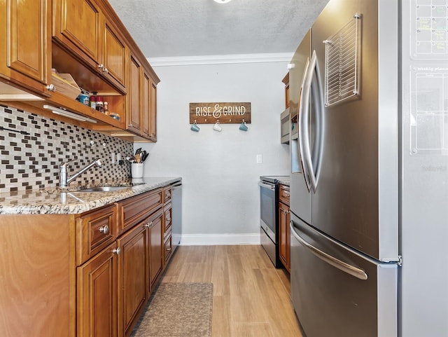 kitchen with sink, stainless steel appliances, tasteful backsplash, ornamental molding, and a textured ceiling