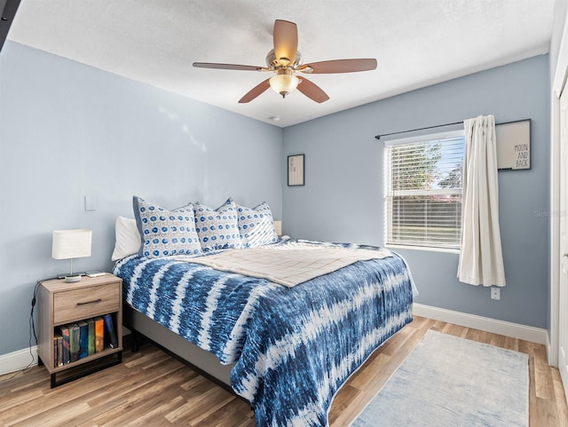 bedroom featuring wood-type flooring, a textured ceiling, and ceiling fan