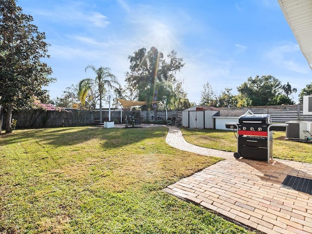 view of yard with central AC, a patio, and a shed