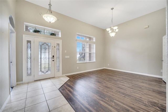 tiled foyer featuring a notable chandelier