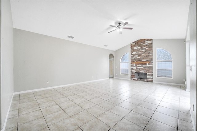 unfurnished living room with ceiling fan, lofted ceiling, a large fireplace, and light tile patterned floors