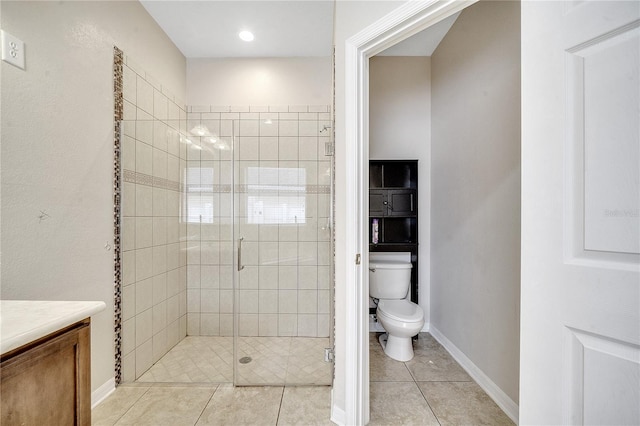 bathroom featuring tile patterned flooring, vanity, a shower with door, and toilet