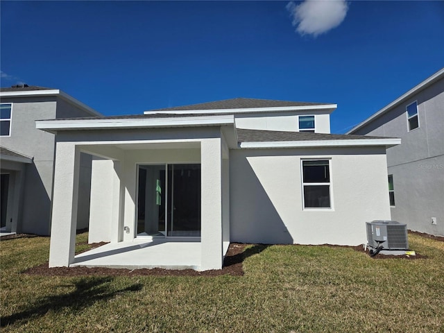 rear view of property featuring a yard, central AC, and a patio area