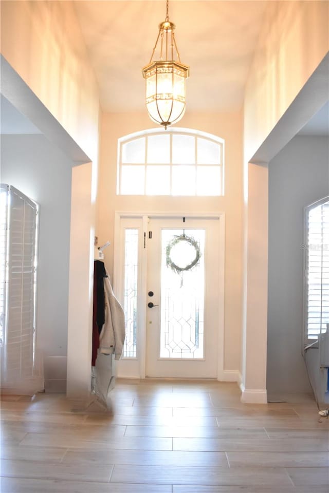 entrance foyer featuring a towering ceiling and light hardwood / wood-style floors