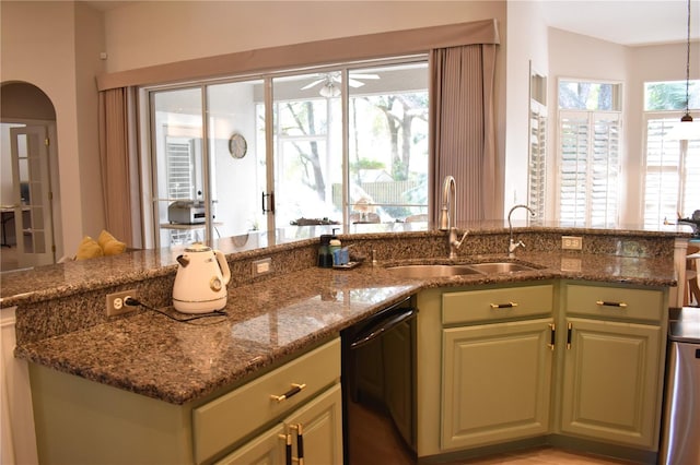 kitchen featuring dishwasher, plenty of natural light, sink, and dark stone counters