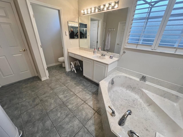 bathroom with vanity, a bath, tile patterned floors, and toilet