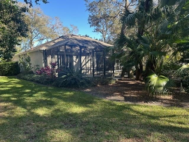 exterior space featuring a yard and a lanai