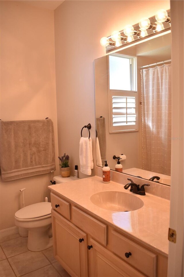 bathroom with tile patterned flooring, vanity, walk in shower, and toilet