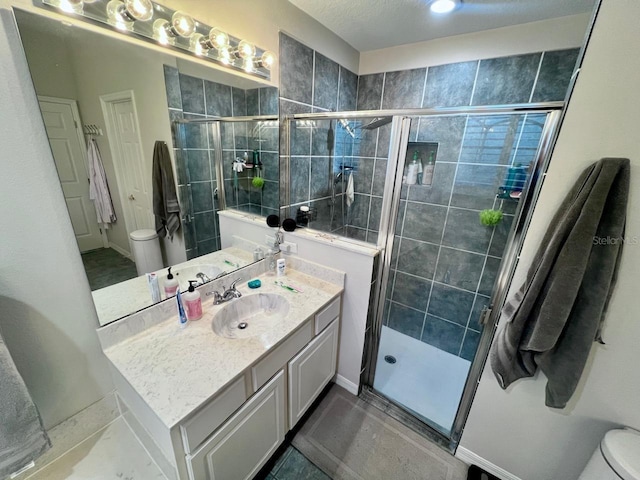 bathroom with vanity, an enclosed shower, and toilet