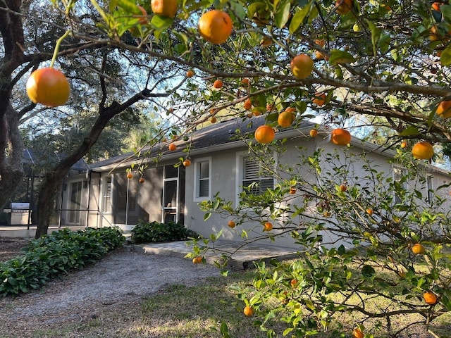 view of side of property with a sunroom and a patio