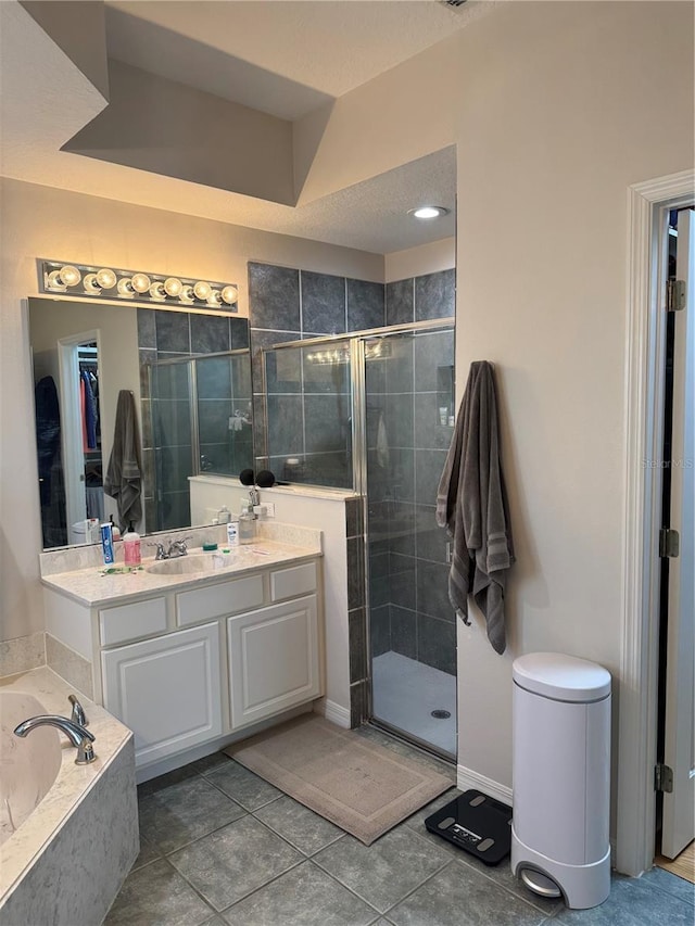 bathroom featuring tile patterned floors, plus walk in shower, and vanity