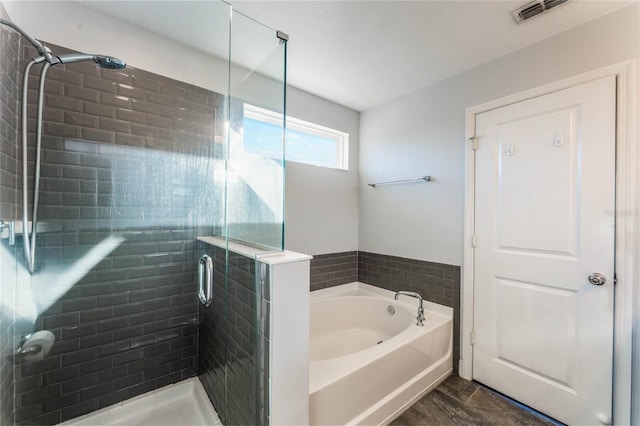 bathroom featuring wood-type flooring and shower with separate bathtub