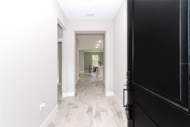 corridor with light hardwood / wood-style floors