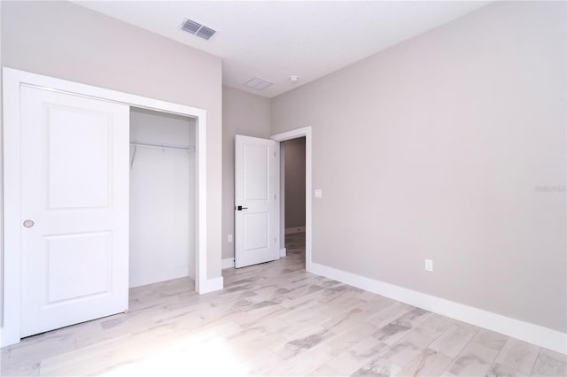 unfurnished bedroom with light hardwood / wood-style floors and a closet