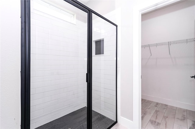 bathroom with wood-type flooring and a shower with shower door