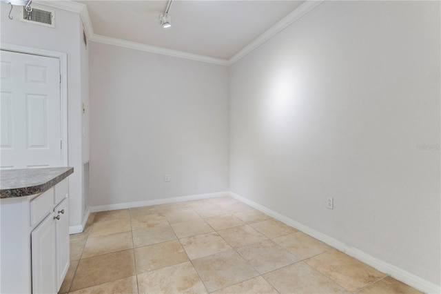 unfurnished dining area with crown molding and track lighting