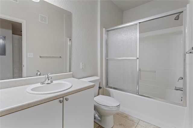 full bathroom with bath / shower combo with glass door, tile patterned floors, vanity, and toilet