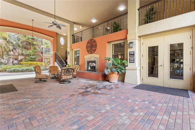 view of patio / terrace with french doors, ceiling fan, and a tiled fireplace