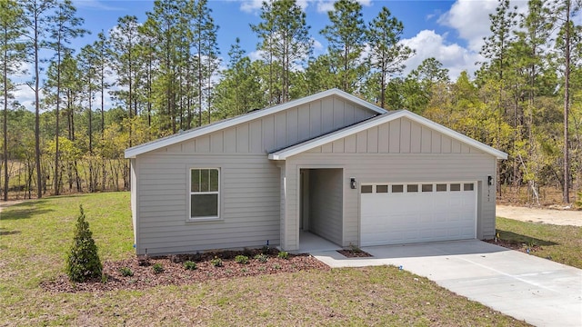 7542 SW 128 Terrace Rd, Dunnellon, FL 34432 - view of front of home with an attached garage, driveway, a front lawn, and board and batten siding