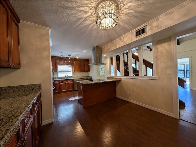 kitchen featuring ornamental molding, island range hood, light stone countertops, and a textured ceiling