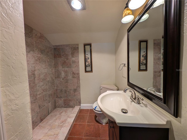 bathroom with tile patterned floors, vanity, toilet, and vaulted ceiling