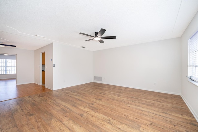 empty room with ceiling fan and light hardwood / wood-style floors