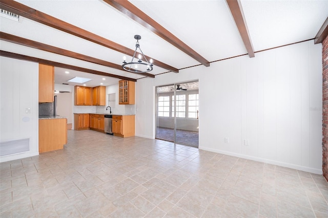 unfurnished living room featuring sink, a notable chandelier, and beam ceiling