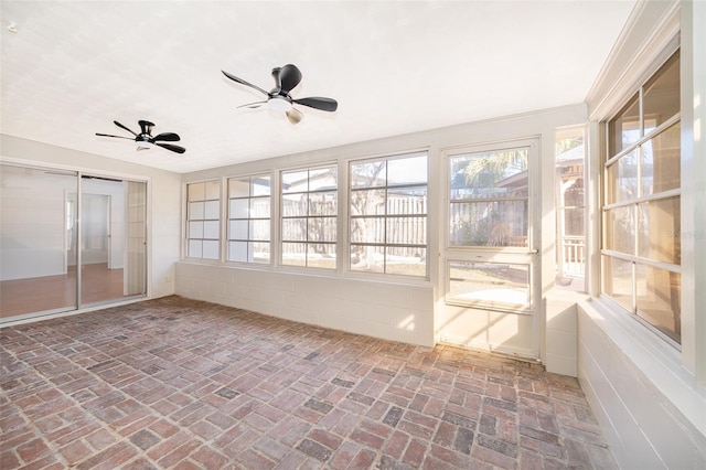 unfurnished sunroom featuring ceiling fan