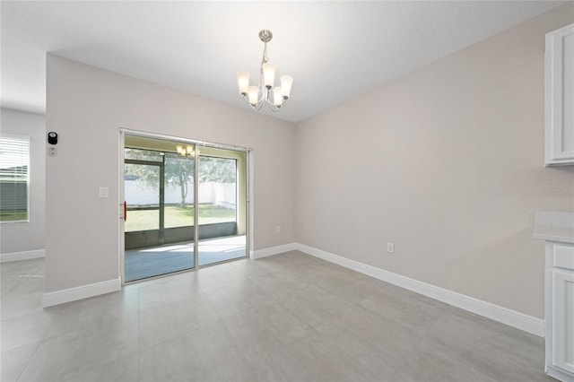 unfurnished dining area featuring an inviting chandelier, a healthy amount of sunlight, and light tile patterned flooring