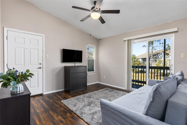 living room featuring vaulted ceiling, dark hardwood / wood-style floors, ceiling fan, and a textured ceiling